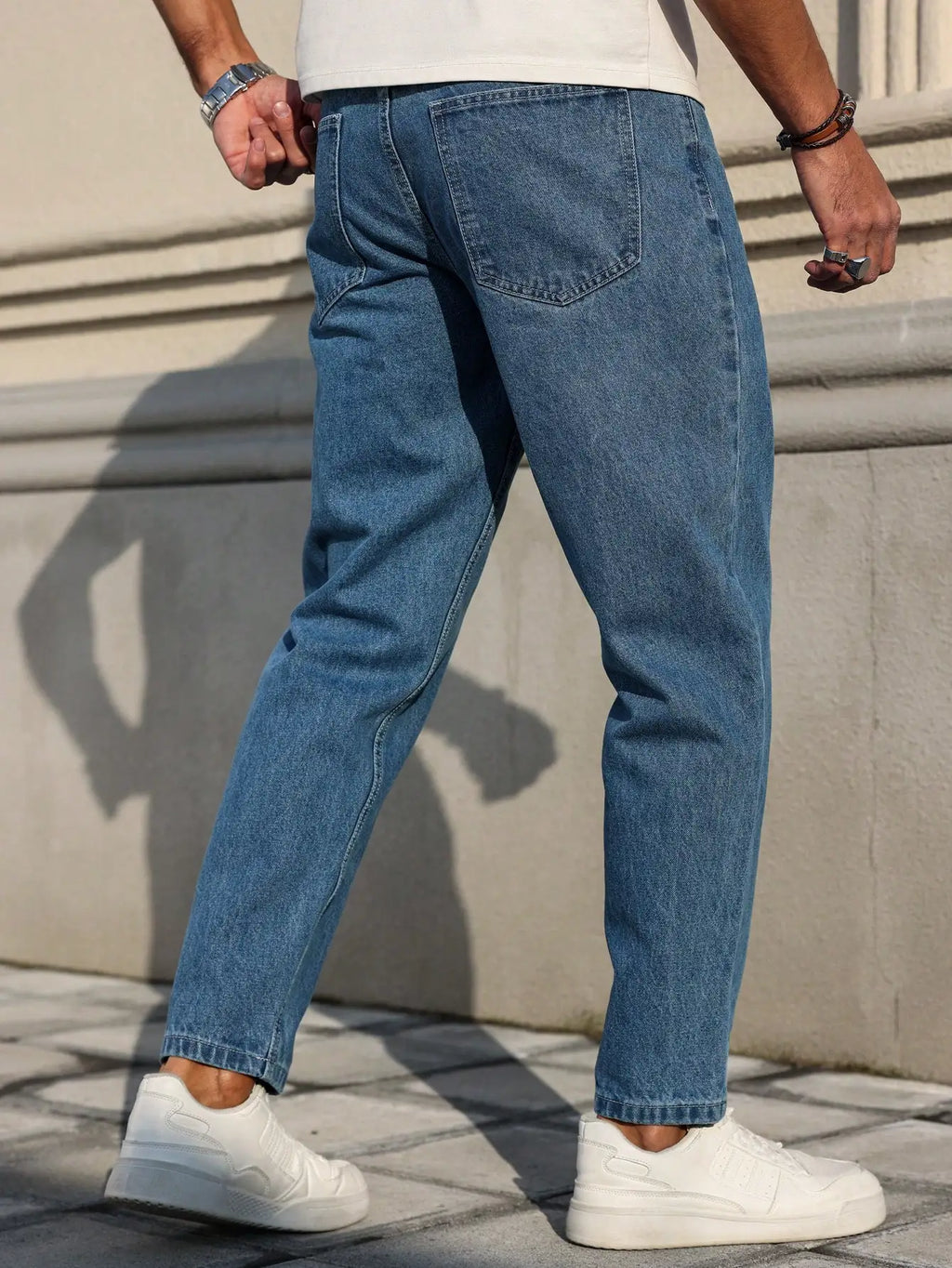 Men's jeans are made of classic blue denim fabric with a loose fit, making them an indispensable versatile item in the wardrobe.